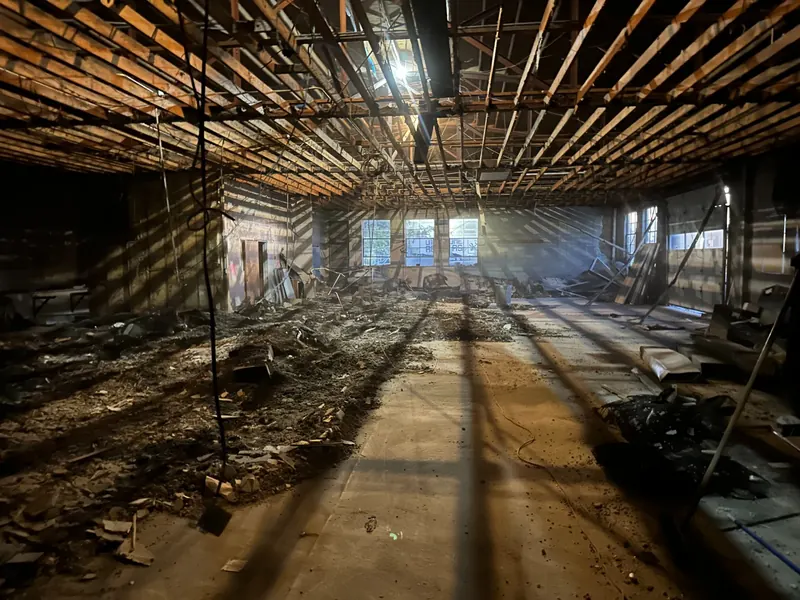 A gutted building interior mid-renovation, with sunlight coming through the windows